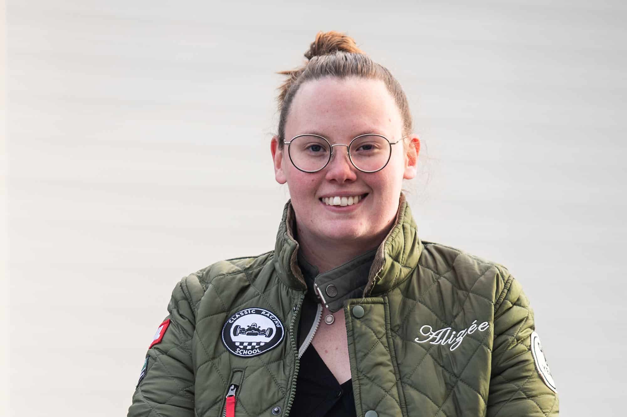 une femme portant des lunettes et une veste verte. L'équipe