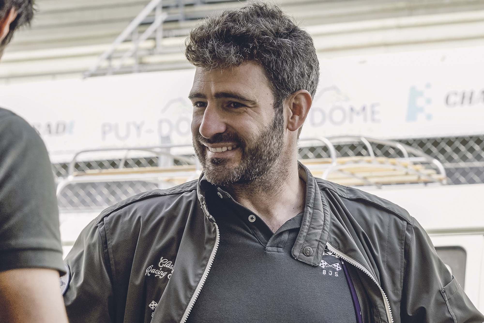 un homme souriant à la caméra. L'équipe